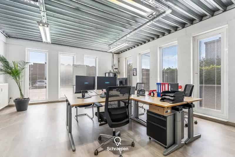Ruim magazijn (450 m²) met kantoorruimtes, buitenopslagplaats en 3 parkeerplaatsen te Genk!