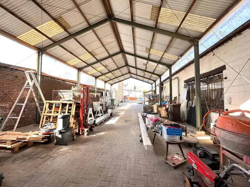 Ruim handelspand met magazijnen, loods, bureelruimte en tuin