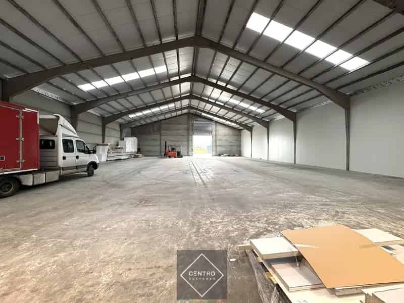 Instapklaar MAGAZIJN (1.200m²), voorzien van 2 LAADKADEN (met levellers), elektrische sectionaalpoort en verhard terrein (voor- en achterkant) op industriezone te Gistel.