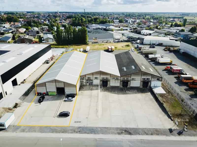 Instapklaar MAGAZIJN (1.250m²), voorzien van 3 elektrische sectionaalpoort, smeerput en verhard terrein (voor- en achterkant) op industriezone te Gistel.